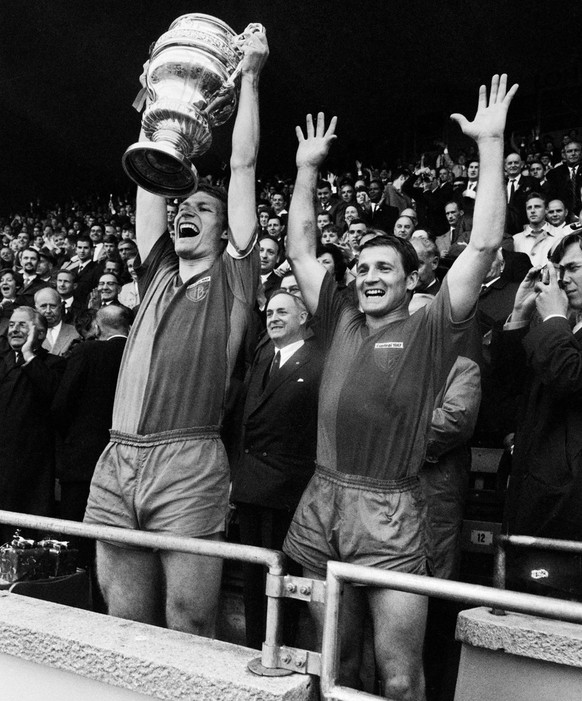 Captain Karl Odermatt, links, und ein weiterer Spieler des FC Basel zeigen den Pokal und jubeln nach dem Sieg im Cupfinal gegen Lausanne-Sports am 15. Mai 1967 im Wankdorf-Stadion in Bern. Nach einem  ...