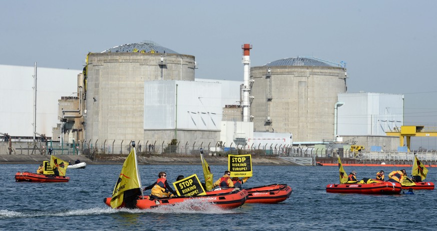 epa04130686 Greenpeace activists on rubber dinghies and holding placards with text reading &#039;Stop Risking Europe!&#039; seen at the Fessenheim nuclear power plant in Fessenheim, France, 18 March 2 ...