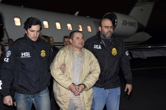 FILE - In this Jan. 19, 2017, file photo provided by U.S. law enforcement, authorities escort Joaquin &quot;El Chapo&quot; Guzman, center, from a plane to a waiting caravan of SUVs at Long Island MacA ...