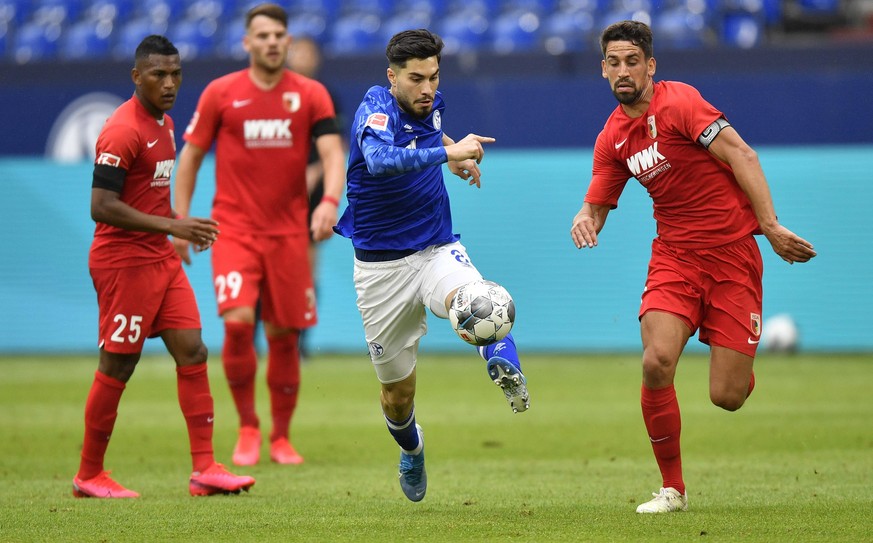 Schalke&#039;s Suat Serdar, second right, kicks the ball by Augsburg&#039;s Rani Khedira, right, during the German Bundesliga soccer match between FC Schalke 04 and FC Augsburg at the Veltins-Arena in ...