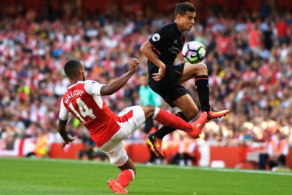 LONDON, ENGLAND - AUGUST 14: Philippe Coutinho of Liverpool is challenged by Theo Walcott of Arsenal during the Premier League match between Arsenal and Liverpool at Emirates Stadium on August 14, 201 ...