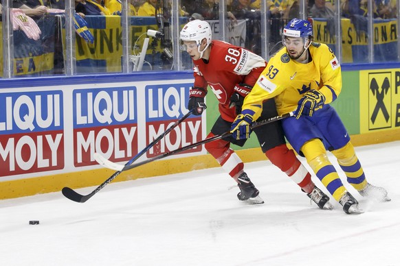 Switzerland&#039;s defender Lukas Frick, left, vies for the puck with Sweden&#039;s forward Mika Zibanejad, right, during the IIHF 2018 World Championship preliminary round game between Switzerland an ...