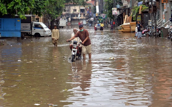 Pakistan: Heavy monsoon rain in Lahore Pakistani pedestrians and motorists wade through a flooded street during heavy monsoon rain in Lahore. More than 100 Pakistanis died in August because of the mon ...