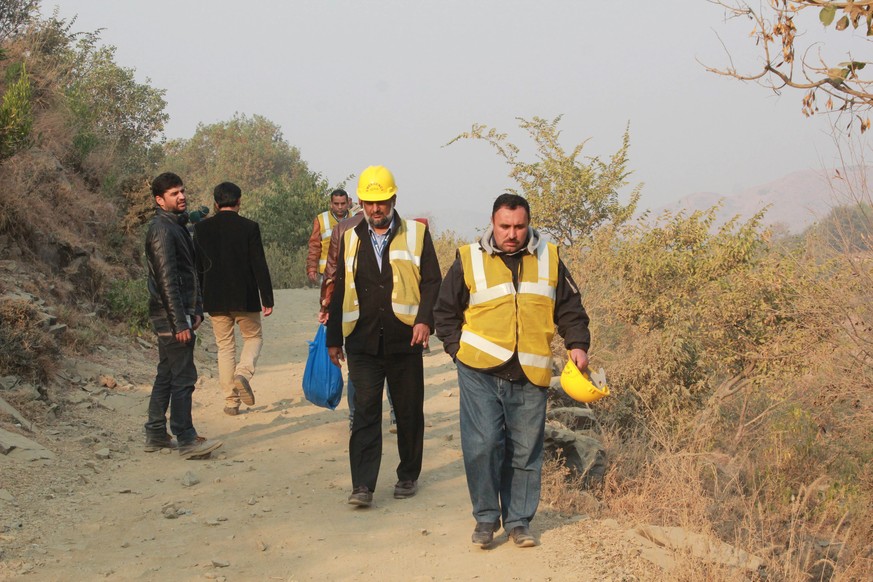 epa05665075 Rescue and Emergency services personel move towards the hill where a Pakistan International Airlines (PIA) ATR-42 turboprop passenger plane crashed near Havelian, Pakistan, 08 December 201 ...