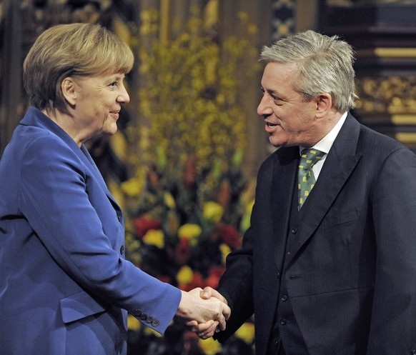 epa07830302 (FILE) - German Chancellor Angela Merkel (L) is greeted by Speaker of the House John Bercow (R) before delivering her address to both Houses in the Royal Gallery at the Houses of Parliamen ...