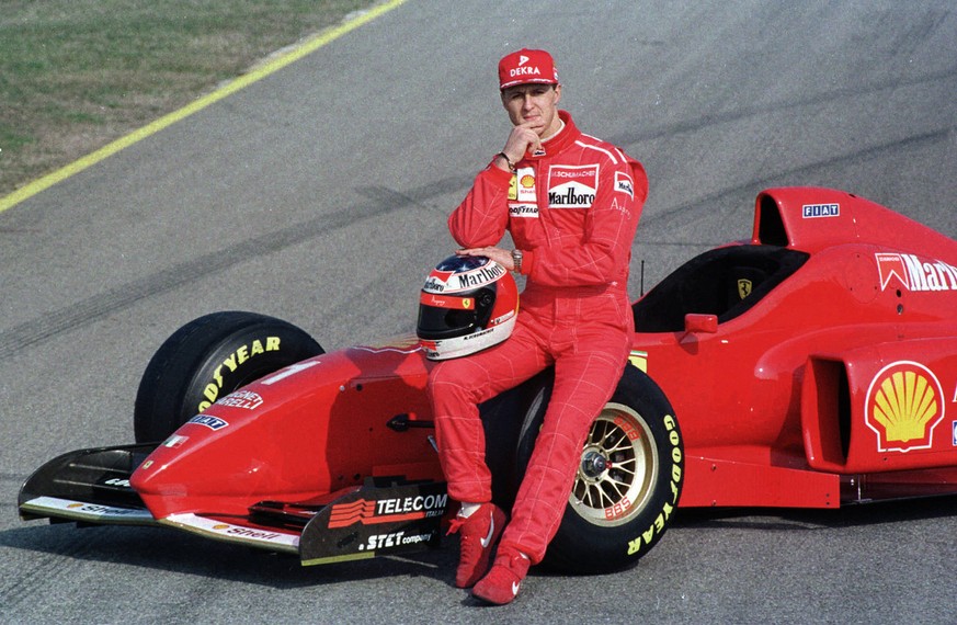 1996 F-1 World Champion Michael Schumacher of Germany, poses for photographers with the new Ferrari F310 F-1 car during the unveiling ceremony, in Maranello, Thursday, February 15, 1996. (KEYSTONE/AP  ...