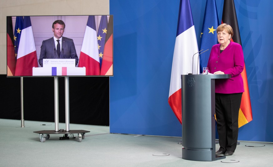 epa08430504 French President Emmanuel Macron (L) and German Chancellor Angela Merkel (R) during a joint video press conference at the Chancellery in Berlin, Germany, 18 May 2020. France and Germany di ...