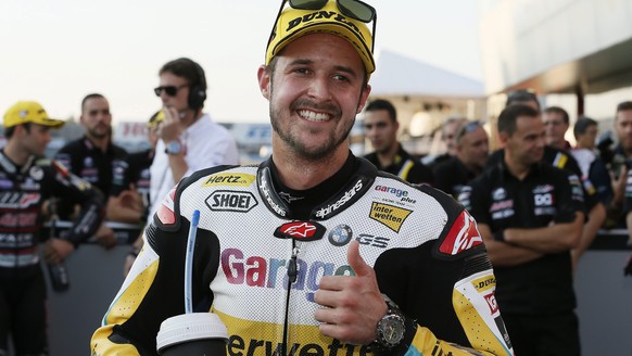 epa05586175 Swiss Moto2 rider Thomas Luethi (C) of Garage Plus Interwetten shows a thumb-up after after placing second in the qualifying of the MotoGP Grand Prix of Japan at Twin Ring Motegi, Tochigi  ...