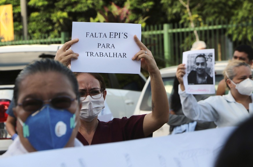 A health professional holds up the Portuguese phrase: &quot;Personal protective equipment is lacking for professionals&quot; during a protest outside &quot;Pronto Socorro 28 de Agosto&quot; Hospital,  ...