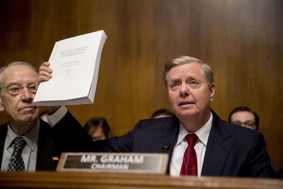 Chairman Sen. Lindsey Graham, R-S.C., right, accompanied by Sen. Chuck Grassley, R-Iowa, left, holds up a copy of the Mueller Report during a Senate Judiciary Committee hearing on Capitol Hill in Wash ...