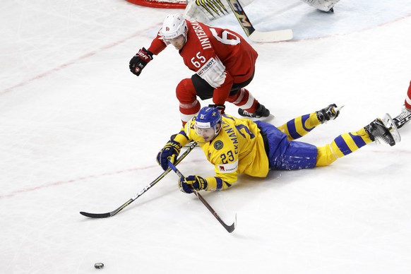 epa06753087 Sweden&#039;s defender Oliver Ekman Larsson #23, vies for the puck with Switzerland&#039;s defender Ramon Untersander #65, right, during the IIHF 2018 World Championship, during the Gold M ...