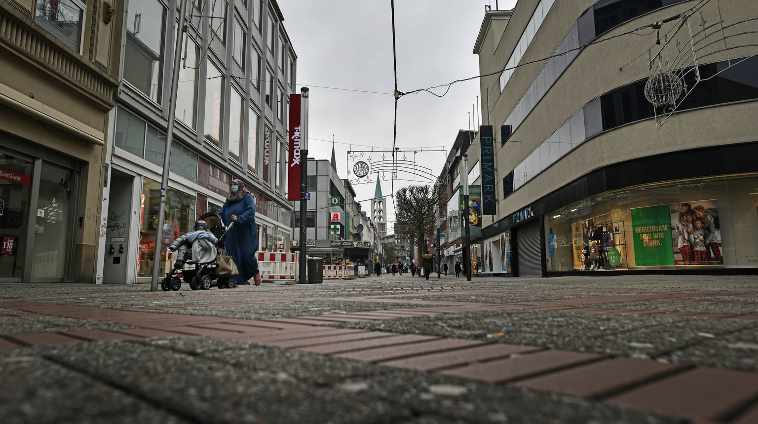 Only a few people walk on the main shopping street during the lockdown in Gelsenkirchen, Germany, Monday, Jan. 11, 2020. The city of Gelsenkirchen is with an incidence of 227 still one of a few region ...