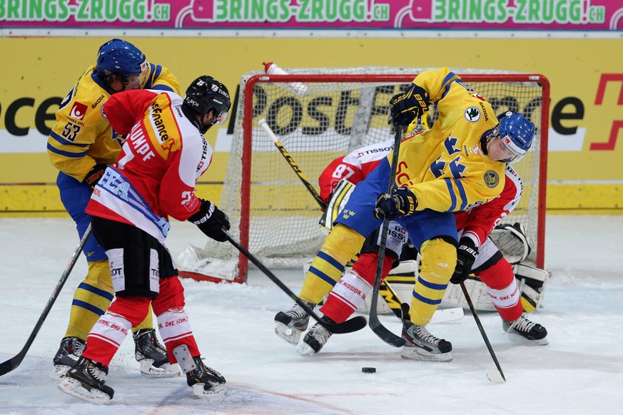 Sweden&#039;s Ted Brithen, right, and Andreas Thuresson, left, fights for the puck against Switzerland&#039;s Dominik Schlumpf, during a test game Switzerland against Sweden in Arosa, Switzerland, Fri ...