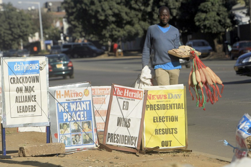 A vendor sells sponges near newspaper headlines on the streets of Harare, Friday, Aug. 3, 2018. Zimbabwe&#039;s President Emmerson Mnangagwa won an election Friday with just over 50 percent of the bal ...