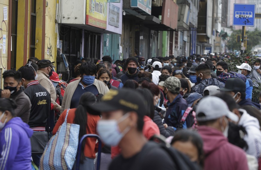 Streets vendors and shoppers wearing masks amid the spread of the new coronavirus fill a street in Lima, Peru, Monday, June 8, 2020, despite an extension of the state of emergency and quarantine, to J ...