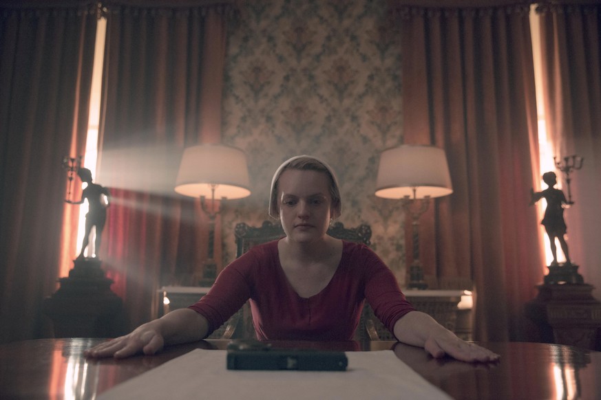 This image released by Netflix shows Elisabeth Moss in a scene from &quot;The Handmaid&#039;s Tale.&quot; The program was nominated for an Emmy Award for outstanding drama series on Tuesday, July 28,  ...