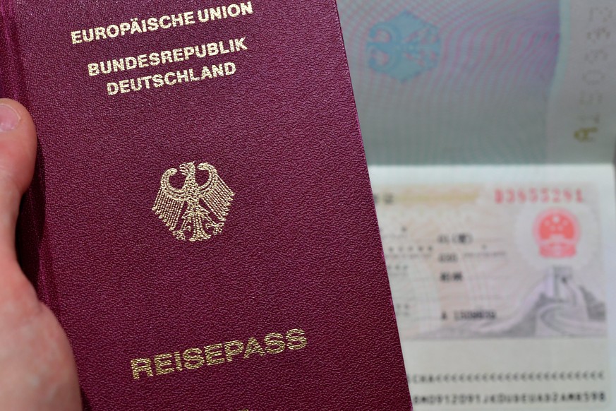epa06292546 A German Passport is laid out next to an official Chinese visa remark (R) in Duesseldorf, Germany, 27 October 2017. For the first time, Singapore is the single most powerful passport in th ...