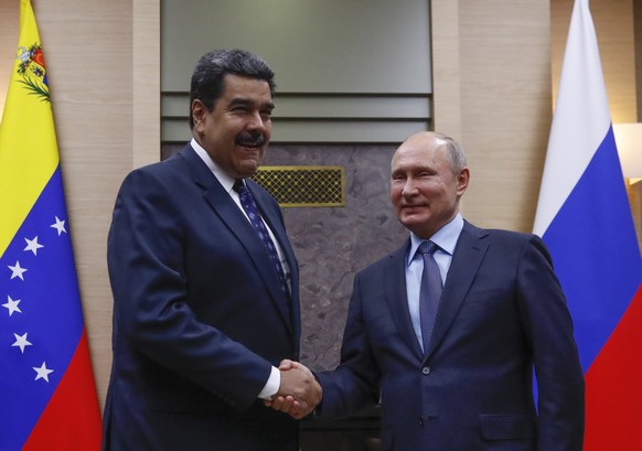 epa07209755 Russian President Vladimir Putin (R) shakes hands with Venezuelan President Nicolas Maduro (L) during a meeting at the Novo-Ogaryovo state residence outside Moscow, Russia, 05 December 201 ...