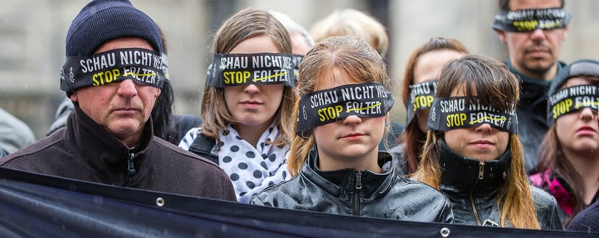 epa04279801 Activists of human rights group Amnesty International wear blindfolds on which are printed with the slogan &#039;Do not look away: stop torture&#039;, in front of Berlin Cathedral in Berli ...