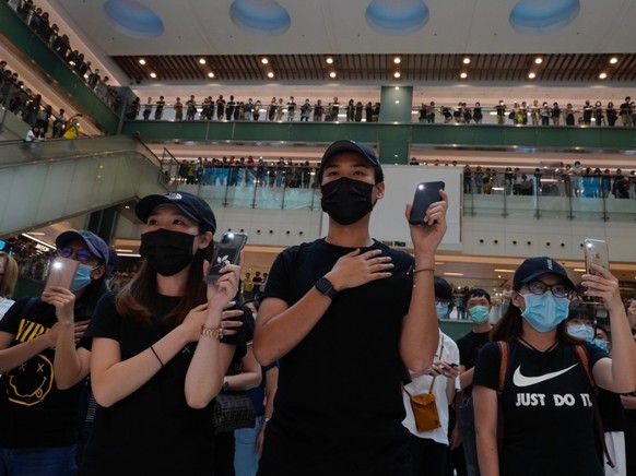 Demonstranten trafen sich in Einkaufszentren und sangen die Protesthymne &quot;Glory to Hongkong&quot;. Trotz eines Vermummungsverbots trugen viele von ihnen Gesichtsmasken, um so ihre Identität zu sc ...