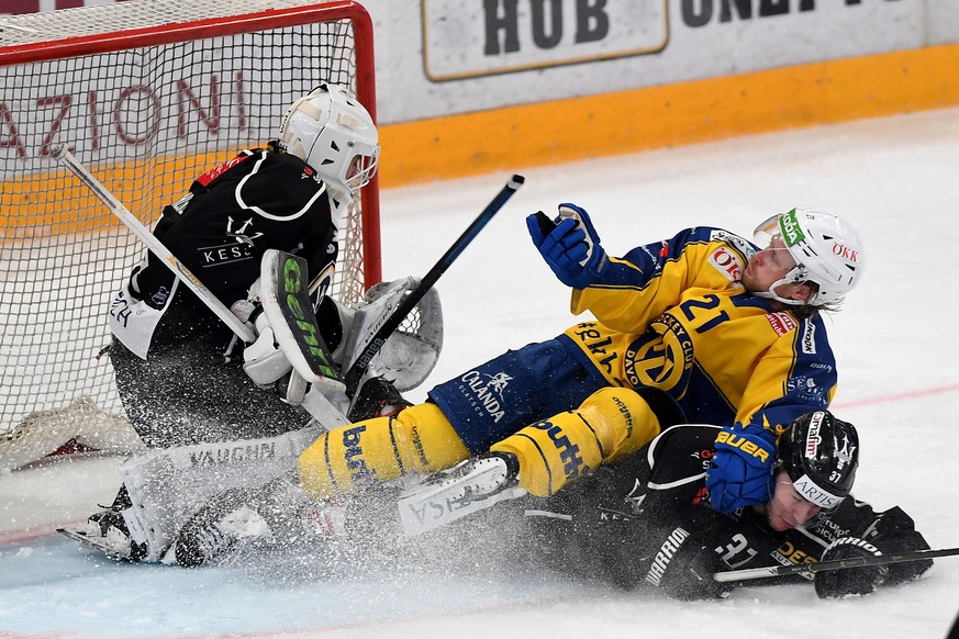 From left Lugano?s goalkeeper Niklas Schlegel, Davos&#039;s player Mattias Tedenby and Lugano?s player Elia Riva, during the preliminary round game of National League A (NLA) Swiss Championship 2019/2 ...