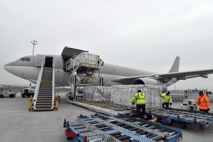 epa09015881 Boxes containing vaccines are unloaded from a Hungarian Airbus 330 cargo plane as the first batch of the vaccine against the new coronavirus produced by Sinopharm of China arrives at Budap ...