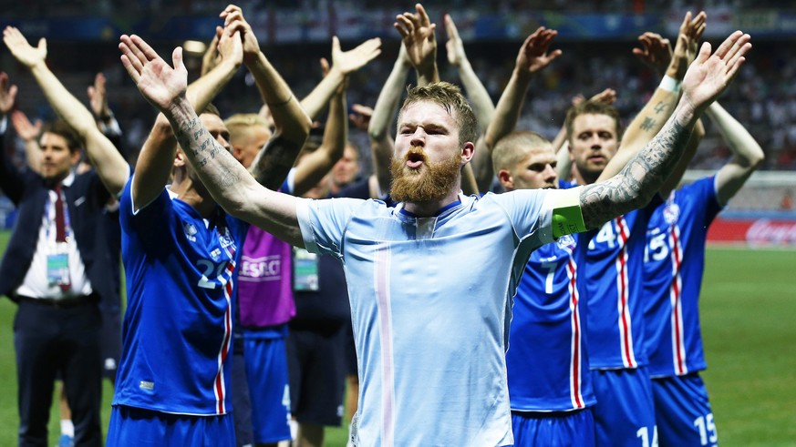 epa05395426 Aron Gunnarsson (front) of Iceland and his teammates celebrate after the UEFA EURO 2016 round of 16 match between England and Iceland at Stade de Nice in Nice, France, 27 June 2016. Icelan ...