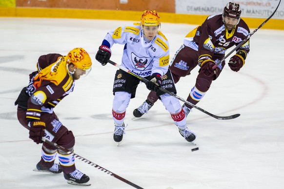 Le top Scorer PostFinance fribourgeois Killian Mottet, centre, a la lutte pour le puck avec le top scorer PostFinance genevois Linus Omark, gauche, et l?attaquant genevois Daniel Winnik, droite, lors  ...