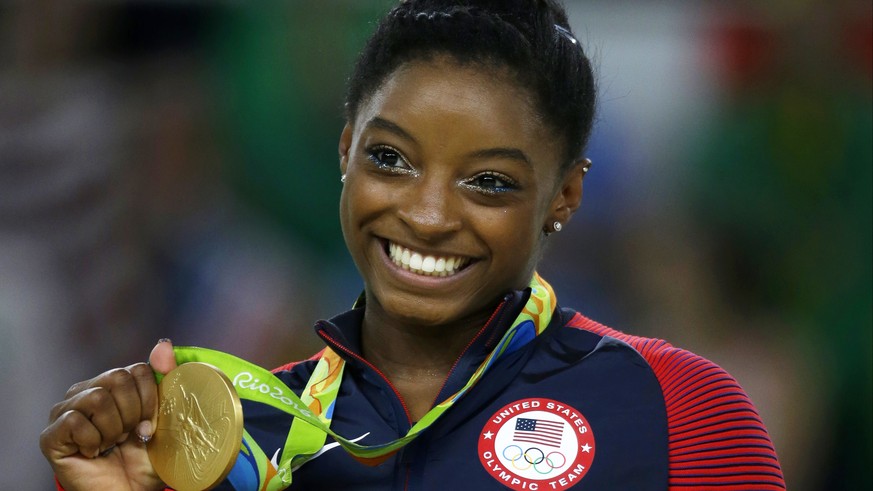 FILE - In this Aug. 16, 2016 file photo, United States gymnast Simone Biles displays her gold medal for floor during the artistic gymnastics women&#039;s apparatus final at the 2016 Summer Olympics in ...