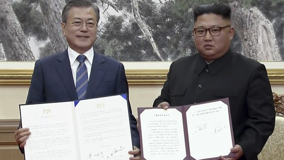 In this image made from video provided by Korea Broadcasting System (KBS), South Korean President Moon Jae-in, left, and North Korean leader Kim Jong Un pose after signing documents in Pyongyang, Nort ...