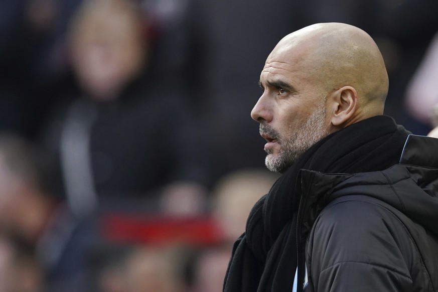 Manchester City&#039;s head coach Pep Guardiola watches the English Premier League soccer match between Manchester United and Manchester City at Old Trafford in Manchester, England, Sunday, March 8, 2 ...