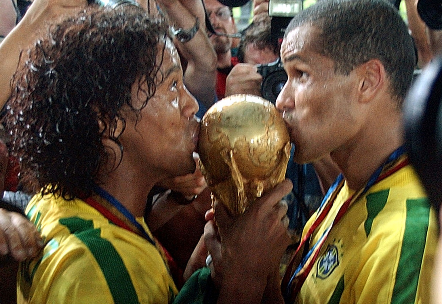 Ronaldinho und Rivaldo küssen den WM-Pokal im Jahr 2002.