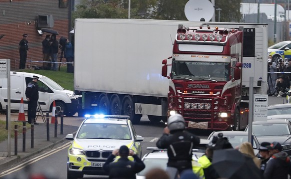 FILE - In this Wednesday Oct. 23, 2019 file photo, police escort the truck, that was found to contain a large number of dead bodies, as they move it from an industrial estate in Thurrock, south Englan ...
