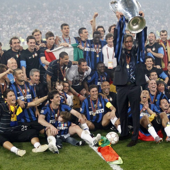 Inter Milan coach Jose Mourinho holds up the trophy surrounded by his team after winning the Champions League final soccer match between Bayern Munich and Inter Milan at the Santiago Bernabeu stadium  ...