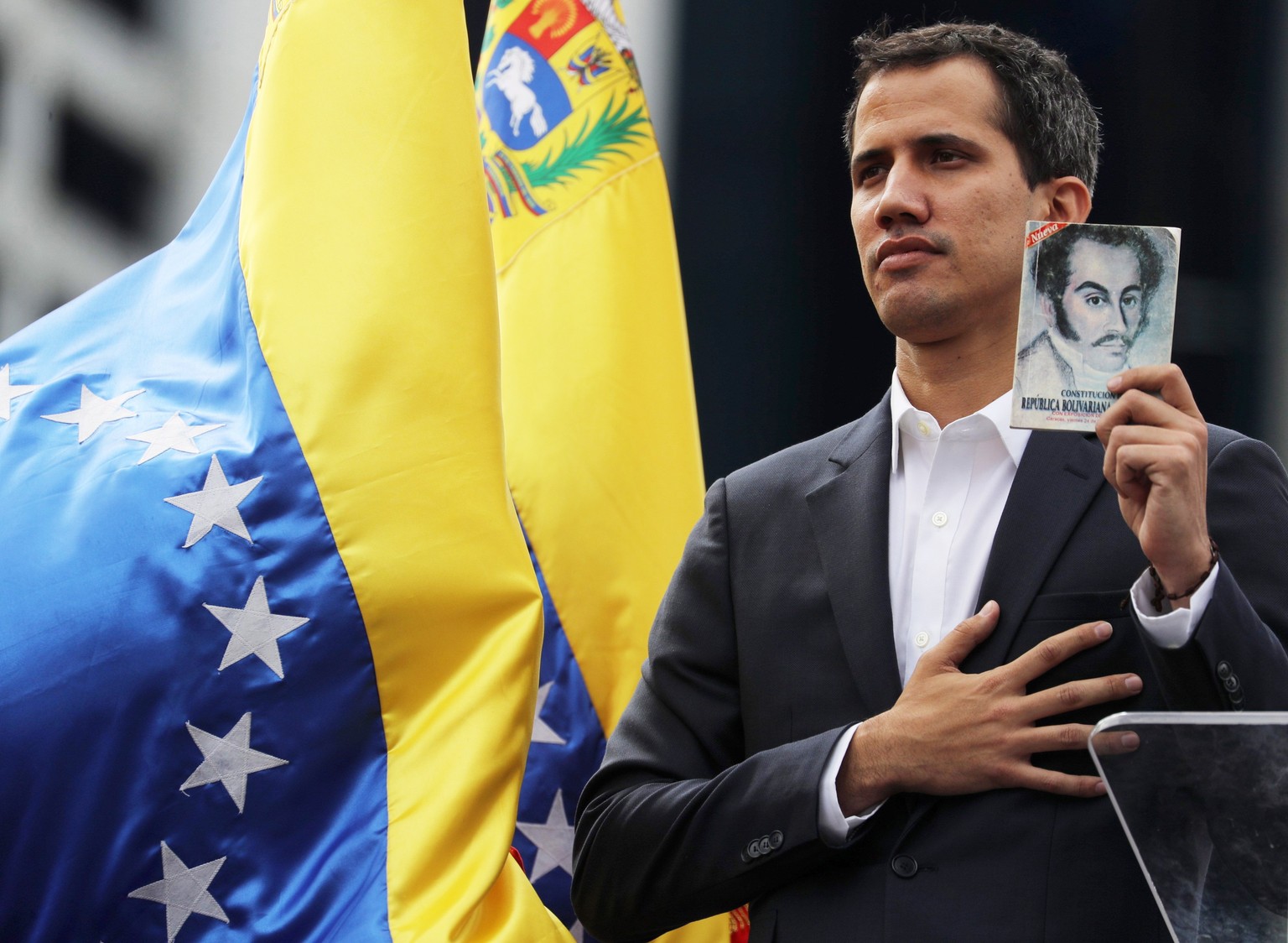 epaselect epa07312932 Juan Guaido, President of the Venezuelan Parliament, poses with a copy of Venezuela&#039;s consitution as he announces that he assumes executive powers, in Caracas, Venezuela, 23 ...