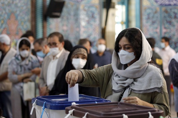 epa09282445 An Iranian woman casts her vote at a polling station during the presidential election in Tehran, Iran, 18 June 2021. Iranians head to polls to elect a new president after eight years with  ...