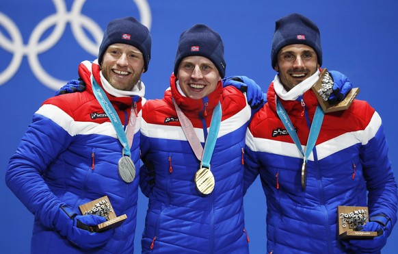 epa06514497 Gold medalist Simen Hegstad Krueger (C) of Norwar is flanked by silver medalist Martin Johnsrud Sundby (L) of Norway and bronze winner Hans Christer Holund of Norway during the medal cerem ...