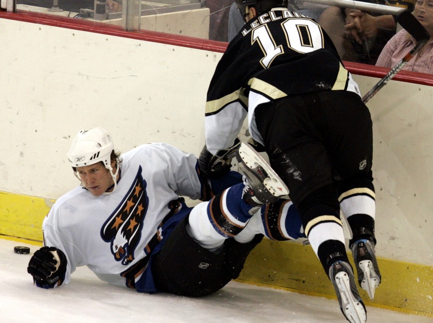 Pittsburgh Penguins John LeClair (10) shoves Washington Capitals defenseman Timo Helbling of Switzerland to the ice during first period of an NHL preseason hockey game on Friday, Sept. 22, 2006 in Pit ...