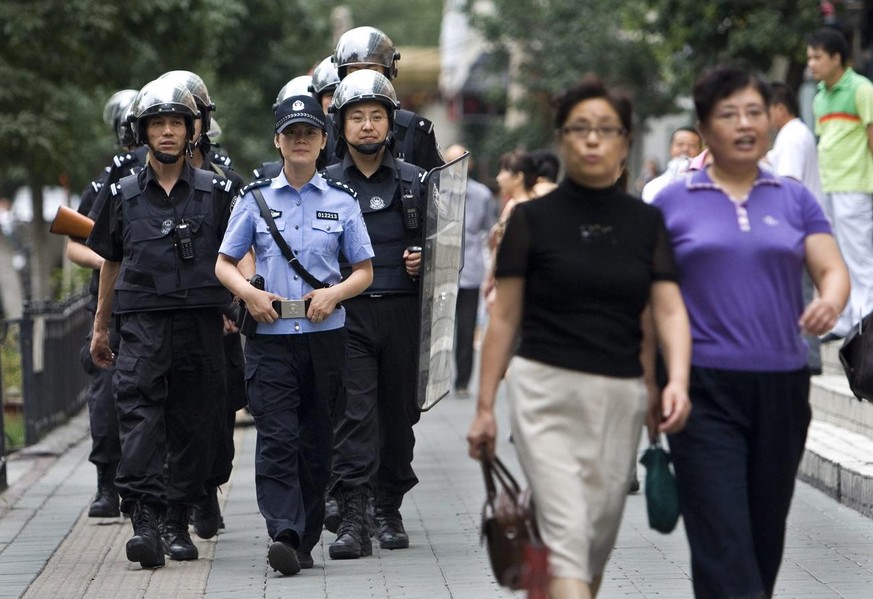 epa01795065 Security forces patrol on a sidewalk across the street from People&#039;s Square in Urumqi, Xinjiang province, China, 15 July 2009. Ten days after the 05 July 2009 deadliest unrest since t ...