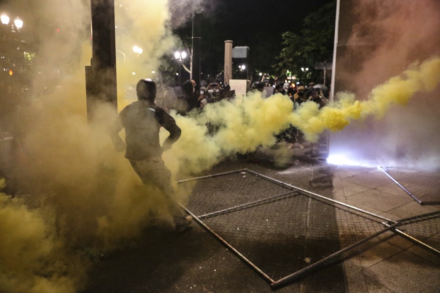 Police respond to protesters during a demonstration, Friday, July 17, 2020 in Portland, Ore. Militarized federal agents deployed by the president to Portland, Oregon, fired tear gas against protesters ...