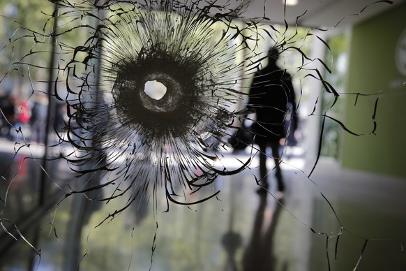 A bullet hole is pictured on a shopwindow of the Champs Elysees boulevard in Paris, Friday, April 21, 2017. France began picking itself up Friday from another deadly shooting claimed by the Islamic St ...