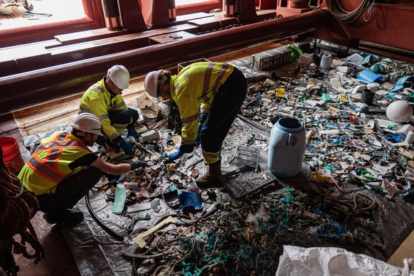 epa07892094 A handout photo made available by The Ocean Cleanup shows crew sorting plastic debris onboard a support vessel of the prototype System 001/B which is capturing plastic debris in the Great  ...