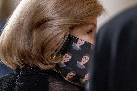 NPR Supreme Court reporter Nina Totenberg wears a face mask with depictions of Justice Ruth Bader Ginsburg on it during a private ceremony for Justice Ginsburg at the Supreme Court in Washington, Wedn ...