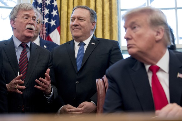 From left, National Security Adviser John Bolton, accompanied by Secretary of State Mike Pompeo, and President Donald Trump, speaks before Trump signs a National Security Presidential Memorandum to la ...