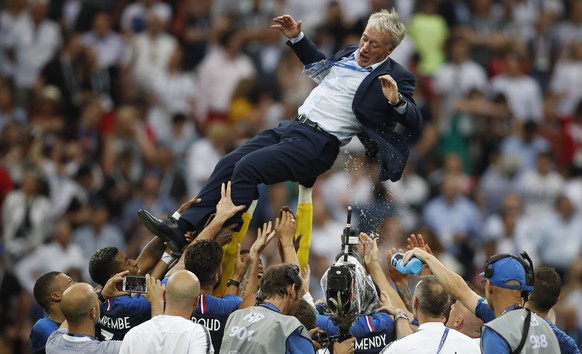 France head coach Didier Deschamps is thrown into the air by his players as they celibate after defeating Croatian in the match between France and Croatia at the 2018 soccer World Cup in the Luzhniki  ...