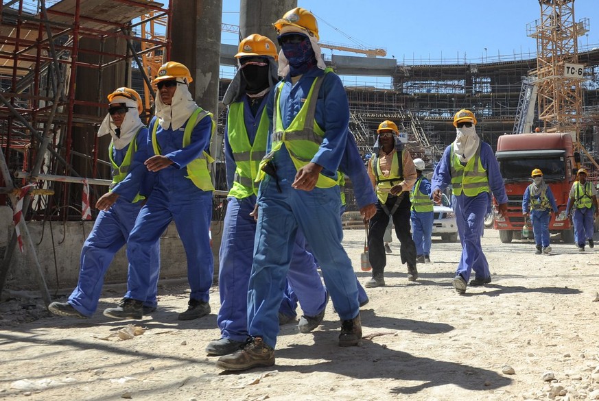epa03956763 Foreign construction workers qleave a construction site in Doha, Qatar, 19 November 2013. The previous day, football&#039;s ruling body FIFA said it will continue to put pressure on 2022 W ...
