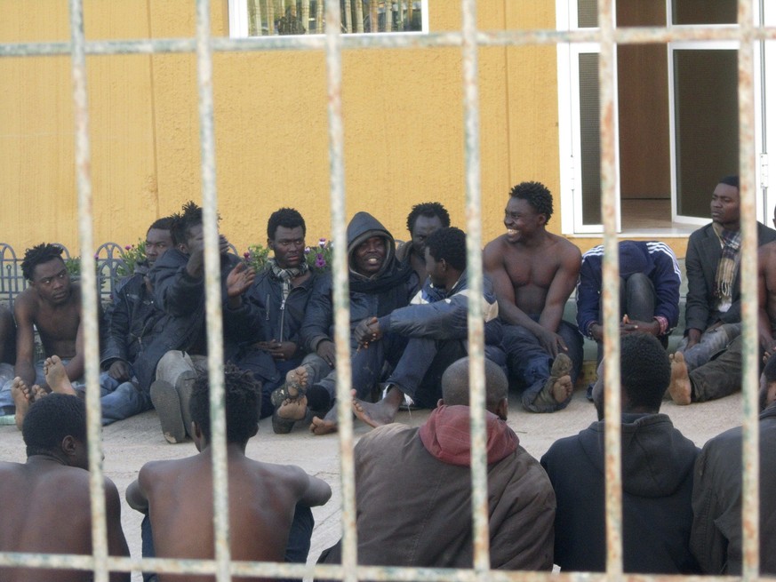 epa04103482 Some of 214 immigrants rest after entering Melilla, a Spanish enclave in northern Africa, during a massive assault against the border, 28 February 2014. More than 200 immigrants have been  ...