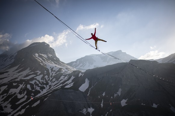 Lukas Irmler balances on a 800 meter long highline 200 meters above Segnesboden with view Piz Segnas, left, and Piz Dolf, on Friday, June 28, 2019, in Flims, Switzerland. The highline is Switzerland&# ...