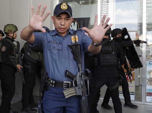 Police prepares to enter a mall in Manila, Philippines Monday, March 2, 2020. Philippine police on Monday surrounded the shopping mall in an upscale section of Manila after a recently dismissed securi ...
