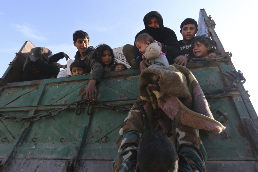 A baby is lifted onto a truck carrying civilians fleeing Maaret al-Numan, Syria, ahead of a government offensive Sunday, Dec. 22, 2019. Syrian government forces pushed deeper in their offensive on the ...